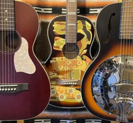custom made guitars hanging on wall at Champlin Guitars store