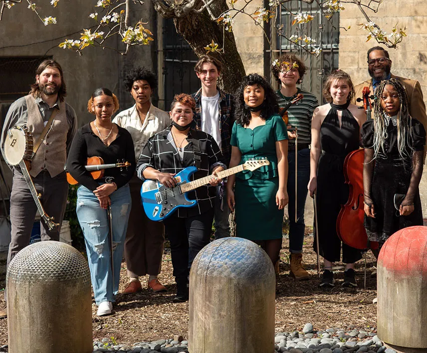Rhapsody Songsters Group Picture outside holding guitar and cello