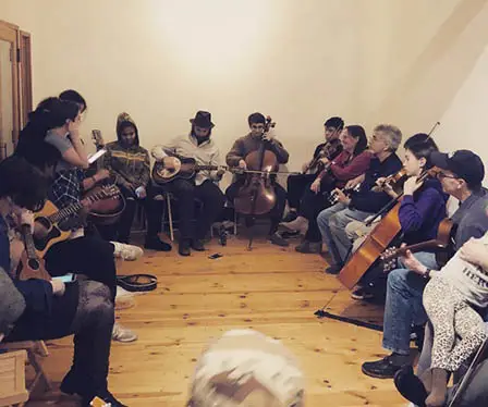 group of musicians playing in a circle at frontier home