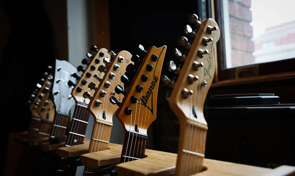 guitar heads lined up in a guitar rack