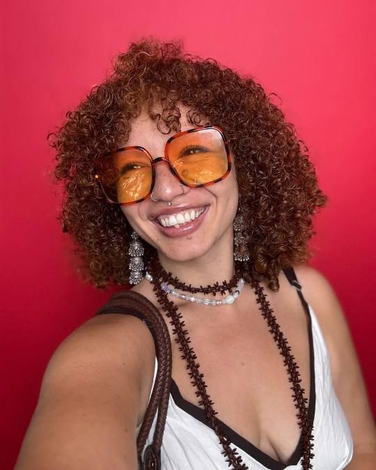 Katana on red background, smiling with orange sunglasses