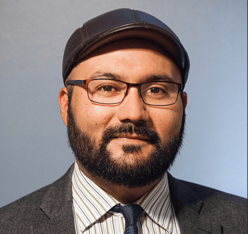 headshot of Dr. Chris Mena on a grayish background
